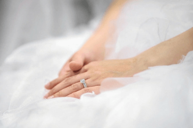 A bride to be wearing a diamond and white gold engagement ring